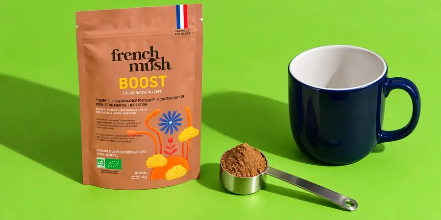 Confezione di French Mush Boost con un misurino di polvere e una tazza vuota su fondo verde
